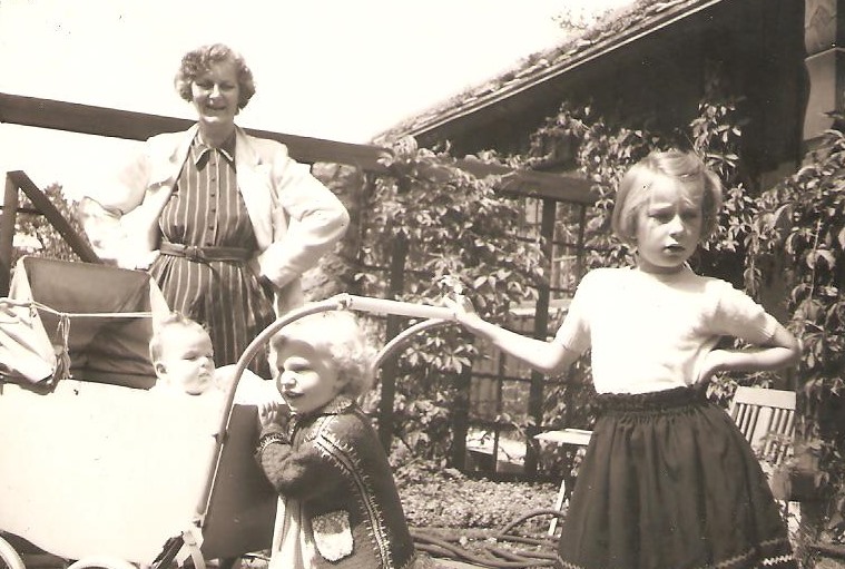 Sort-hvitt foto fra 1953 av Charlotte Koren som barn med mormor og søstrene foran mormorens hus på Lillevann.